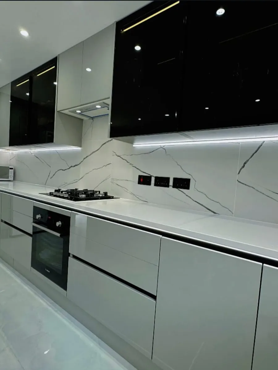 Black and grey gloss wall units over a marble-effect splashback